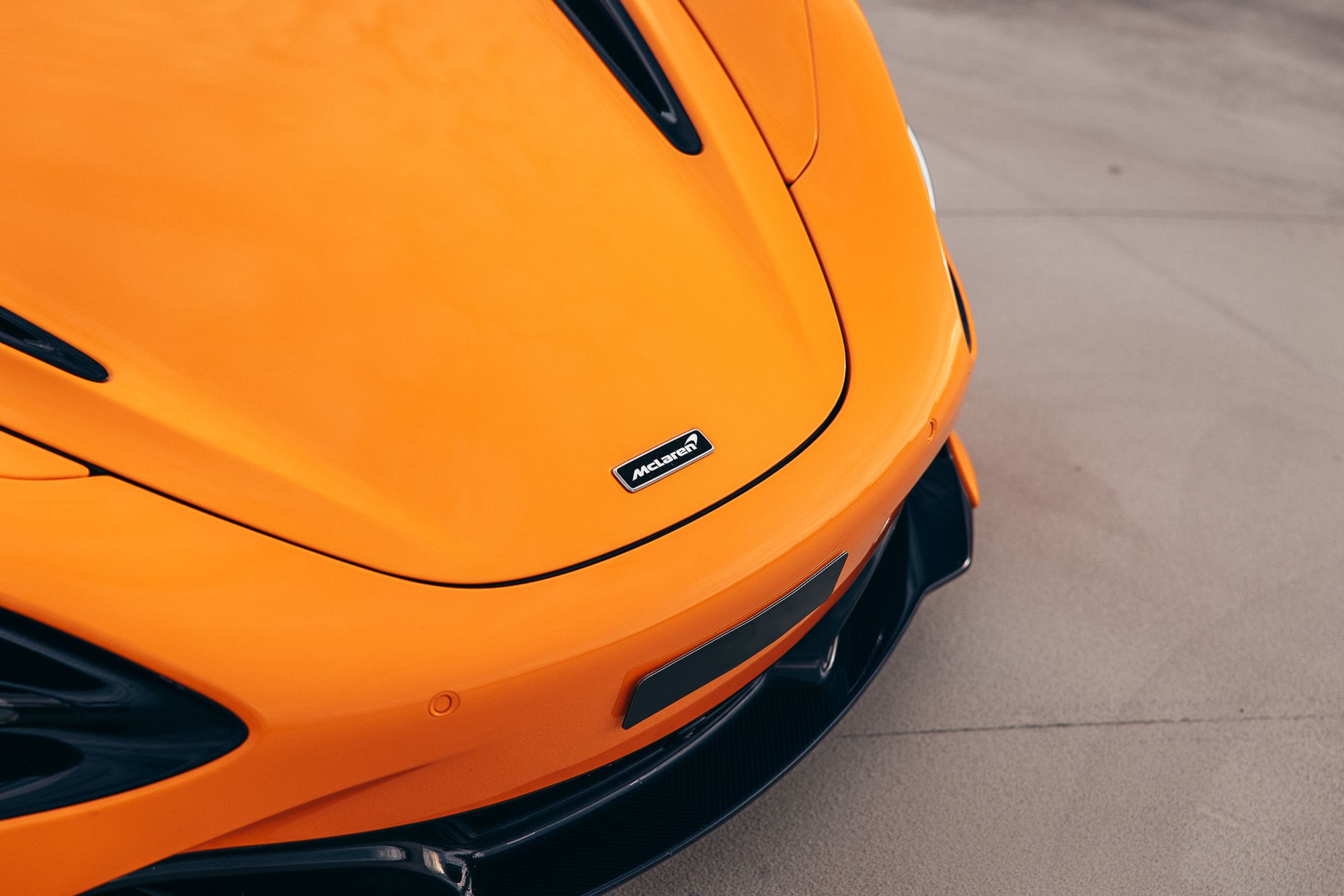 Glanzende oranje motorkap van een McLaren