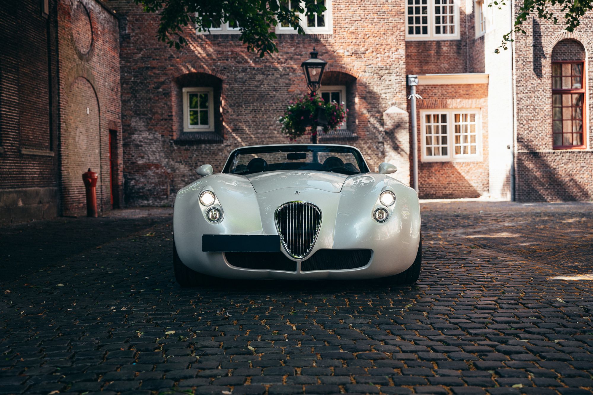 Witte Wiesmann Roadster op een historische binnenplaats